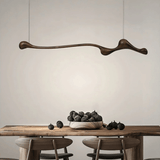 Modern dining room with a wooden table, chairs, and a decorative pendant light.