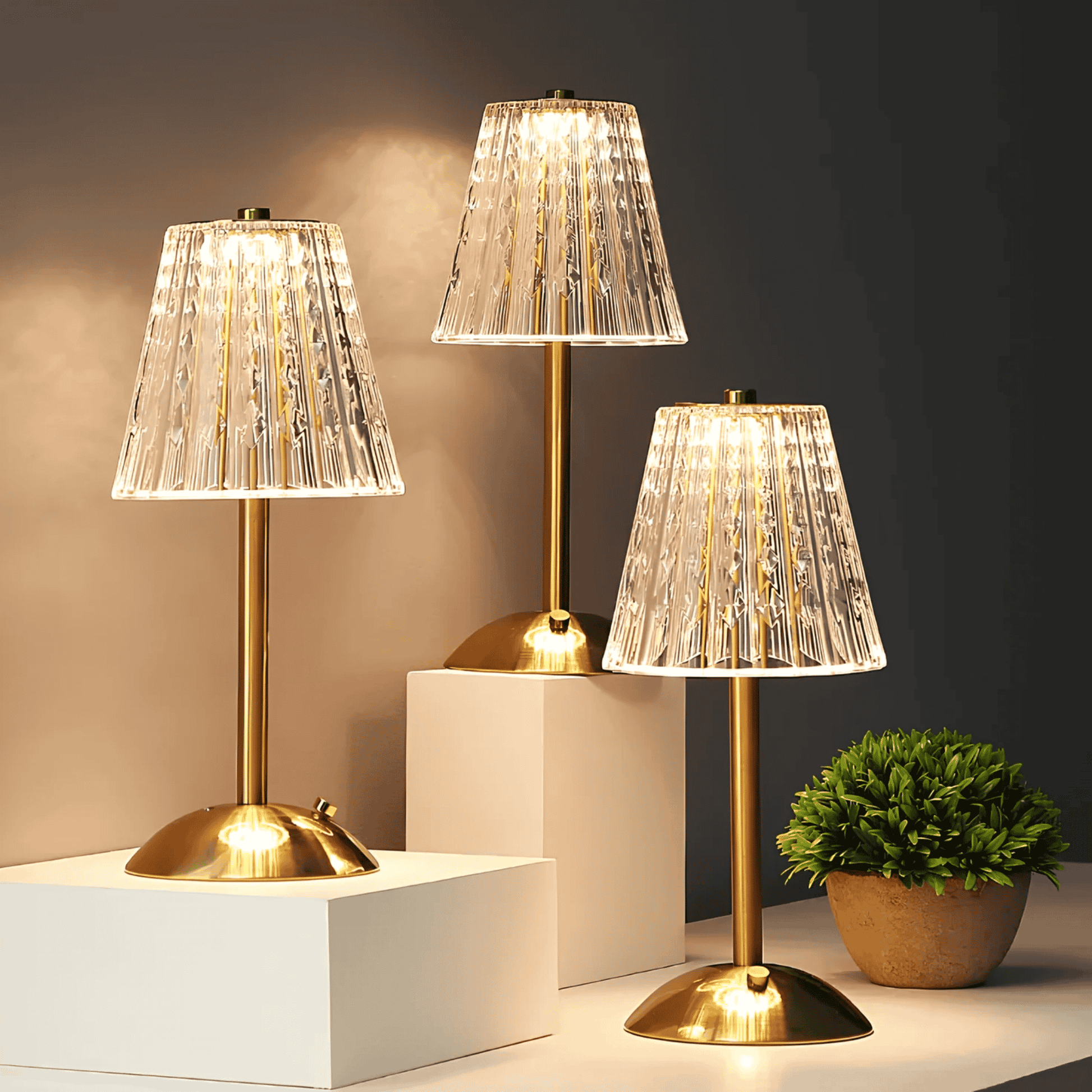 Three table lamps with gold bases and clear glass shades on a dark background.