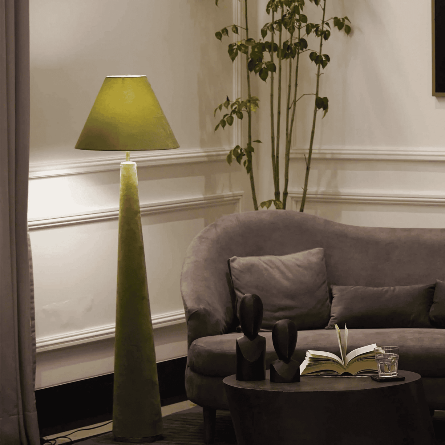 Living room with a green floor lamp, gray sofa, and decorative items.