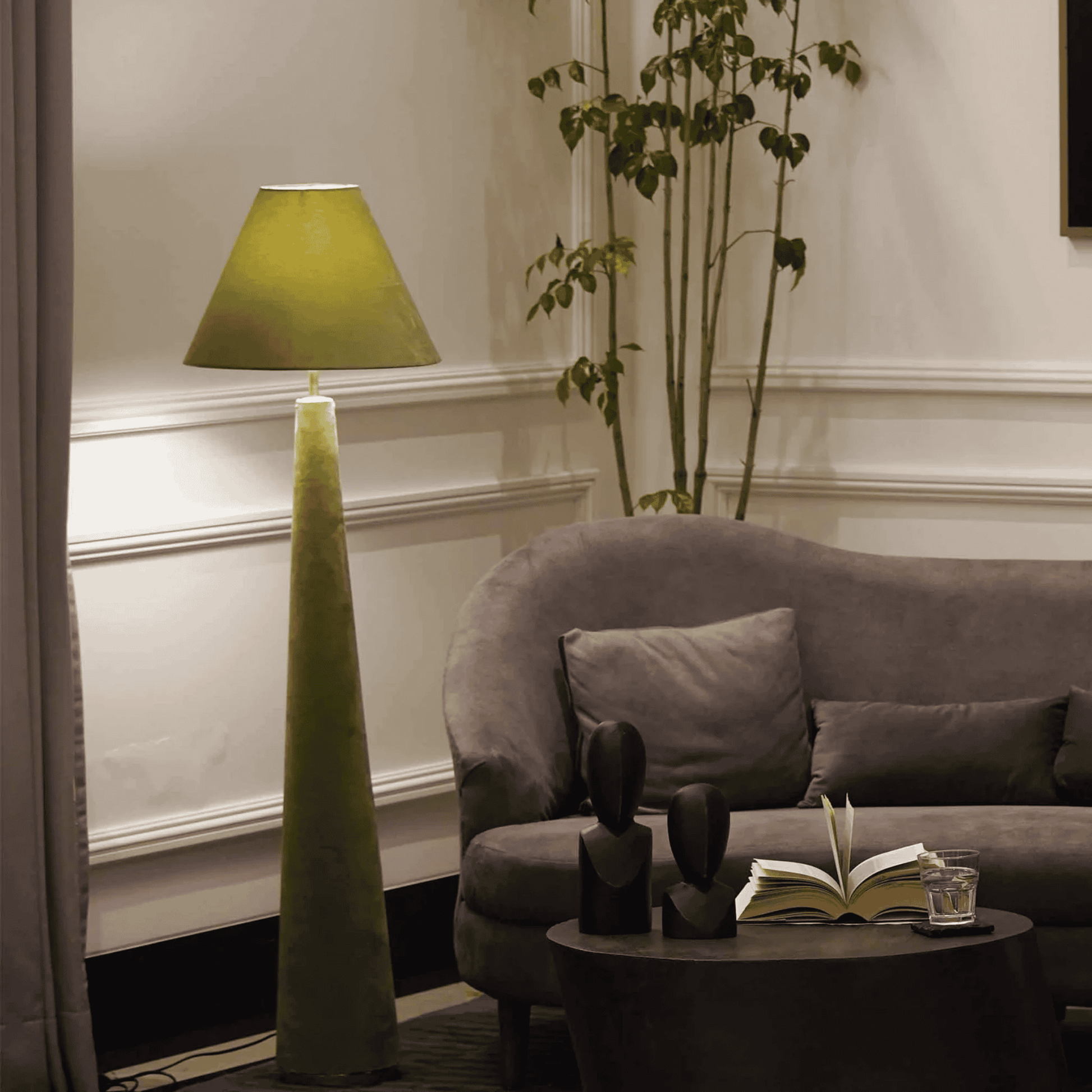 Living room with a green floor lamp, gray sofa, and decorative items.