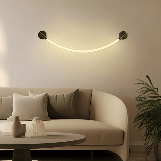 Modern wall light fixture in a living room setting with a beige sofa and decorative items.