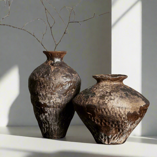 Two rustic brown ceramic vases on a white background