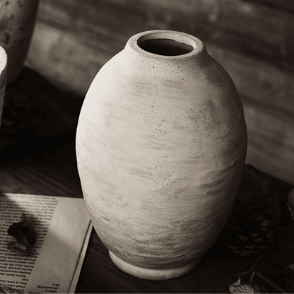 Textured ceramic vase on a wooden surface with a blurred background