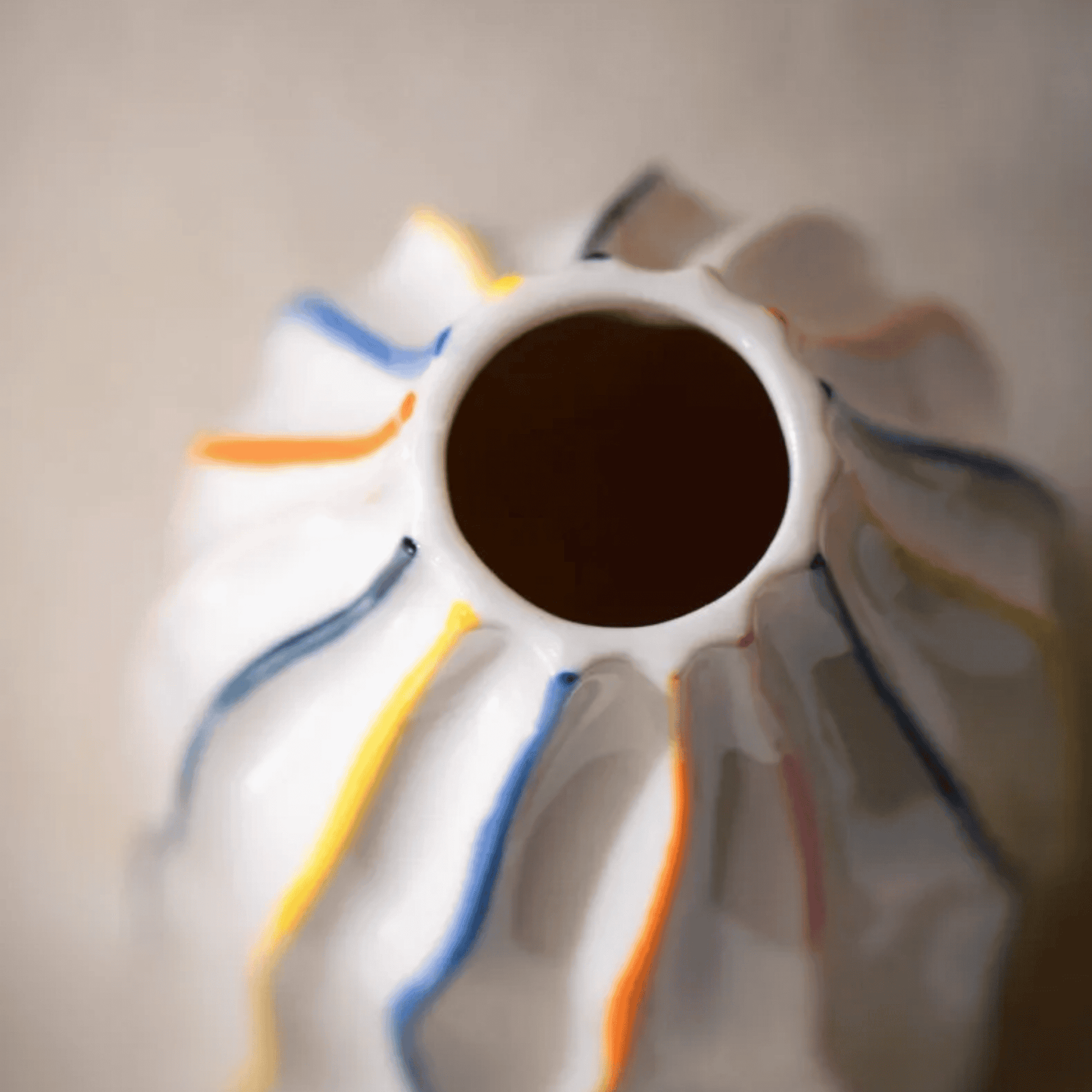 Close-up of a ceramic vase with colorful stripes on a neutral background