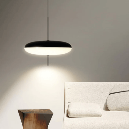 Modern pendant light hanging above a bed in a bedroom setting