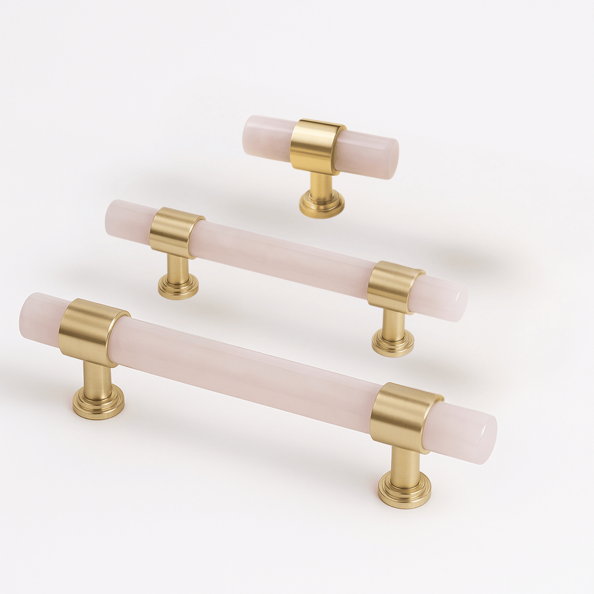 Set of gold and pink cabinet handles on a white background
