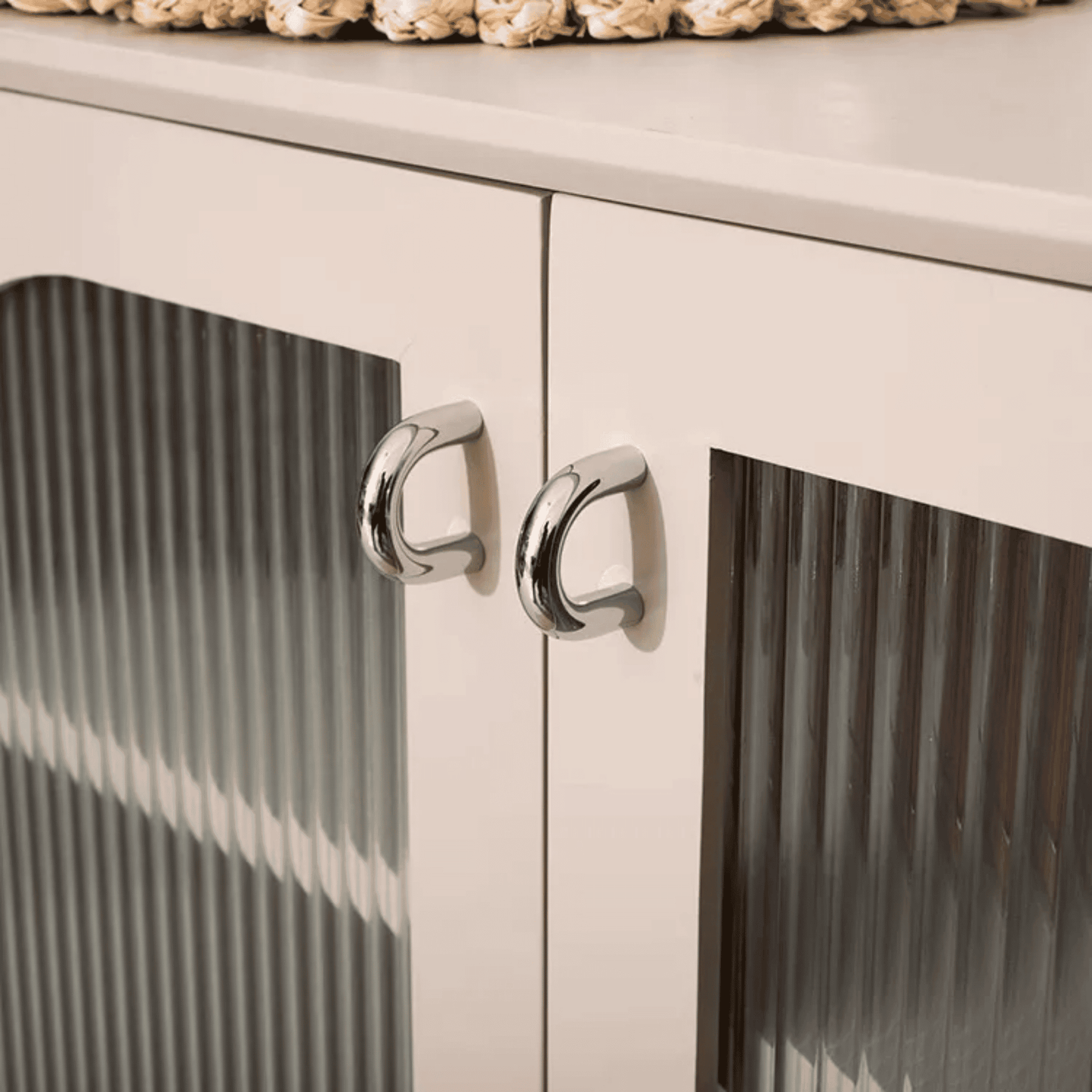 Close-up of a white cabinet with silver knobs on a white background