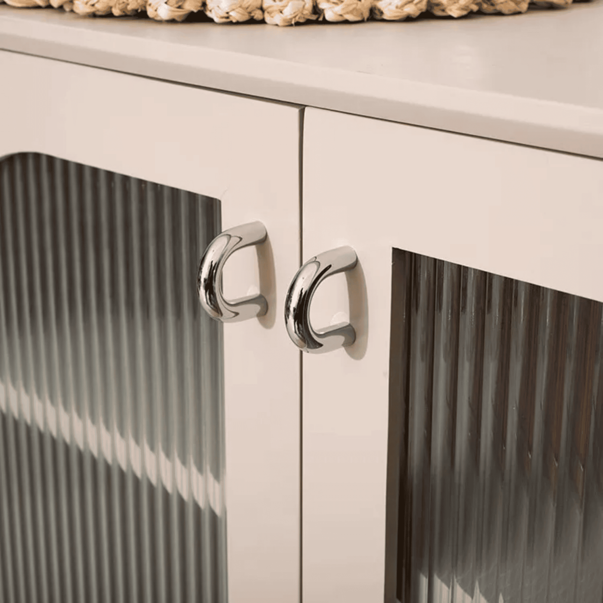 Close-up of a white cabinet with silver knobs on a white background