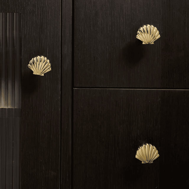 Black cabinet with gold shell-shaped knobs