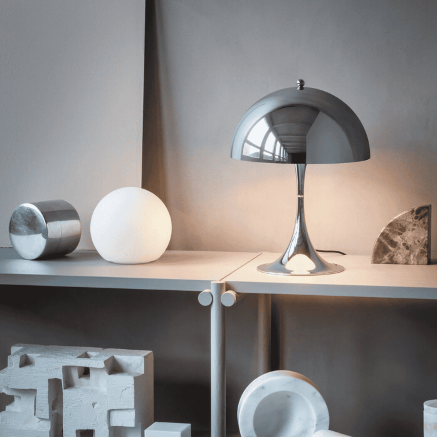 Modern table lamp on a surface with decorative items in a minimalistic setting