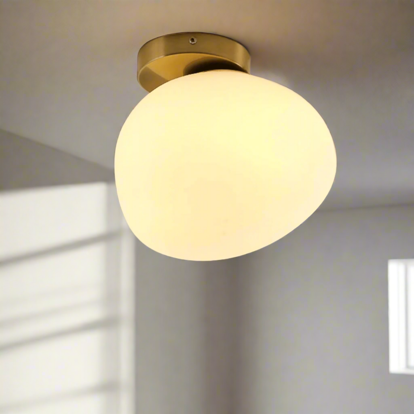 Ceiling light fixture with a glass shade on a plain background