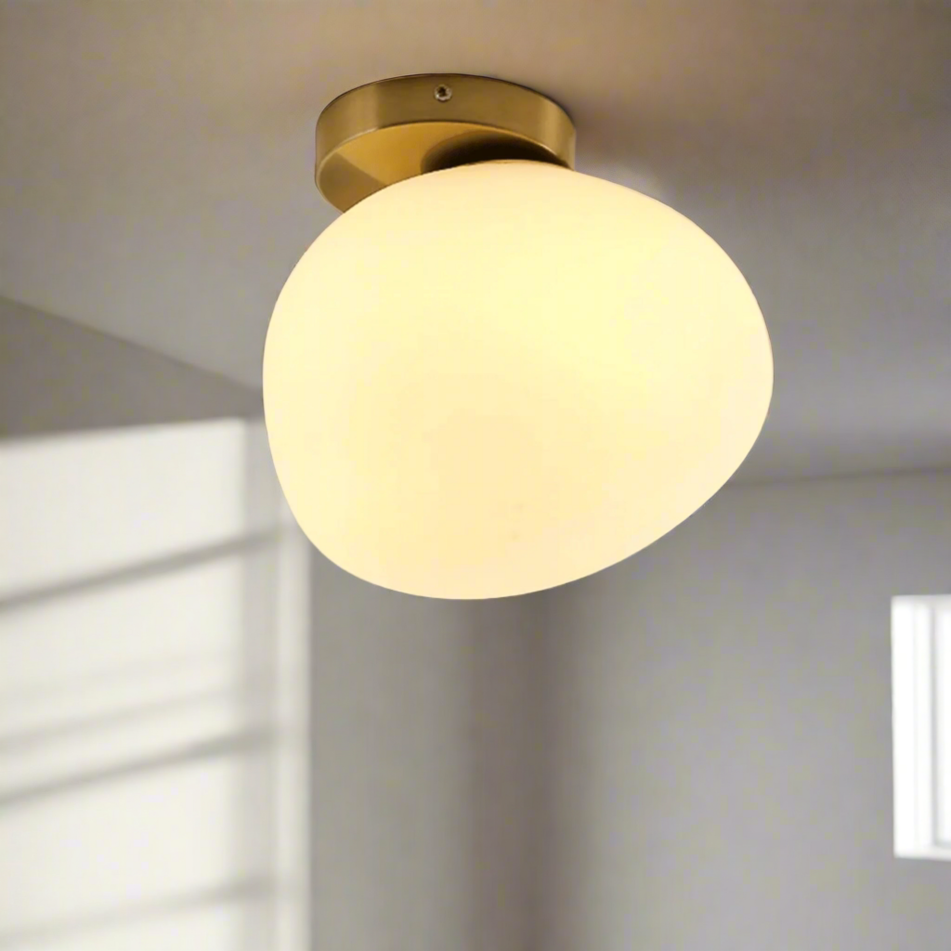 Ceiling light fixture with a glass shade on a plain background