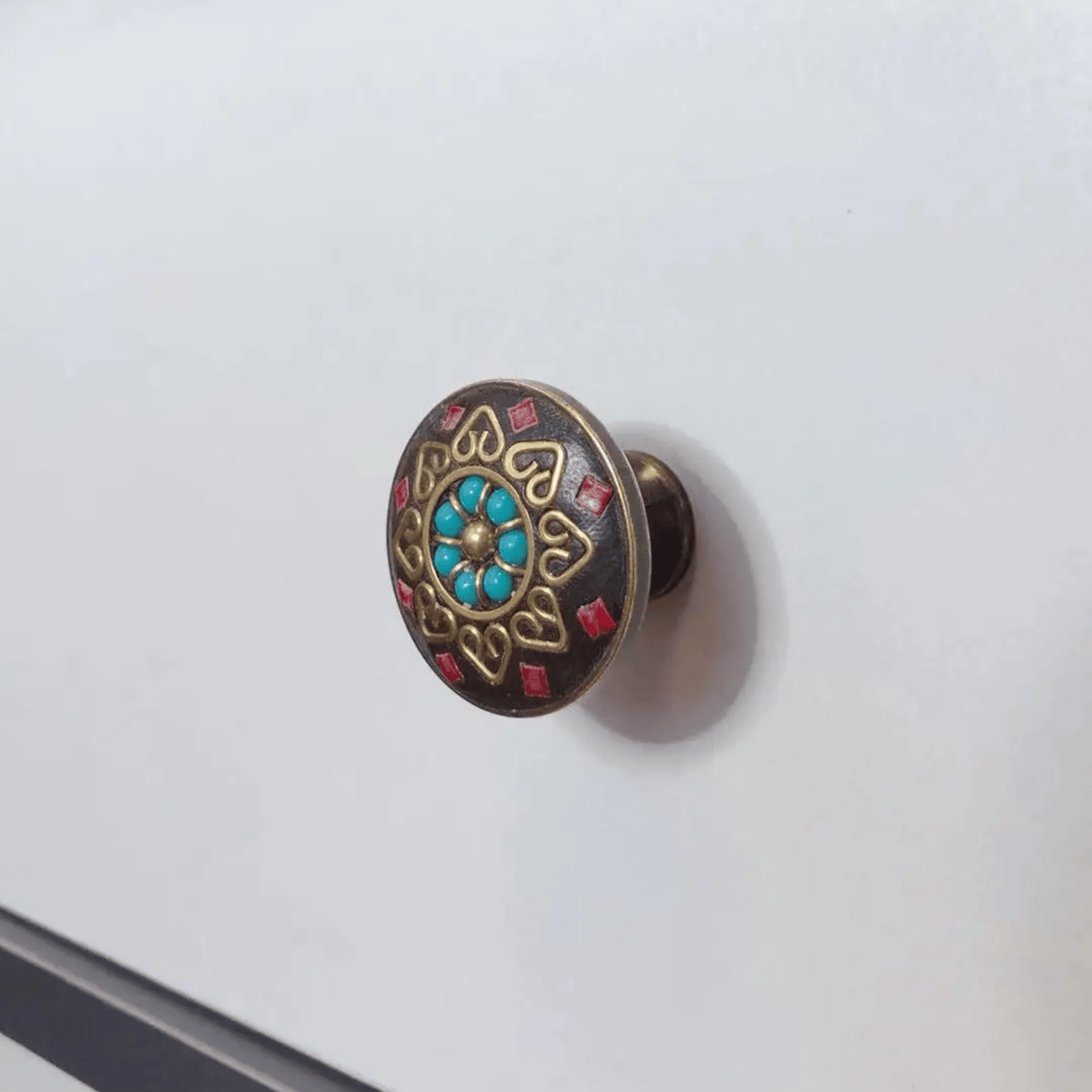 Decorative cabinet knob with gemstones on a white background