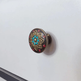 Decorative cabinet knob with gemstones on a white background