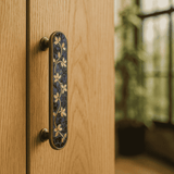 Decorative door handle on a wooden door with a blurred background