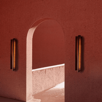 Archway framed by two wall lights against a red wall