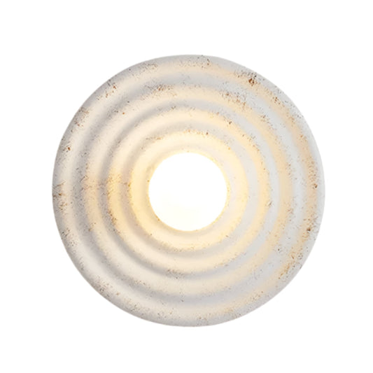 Round light fixture with a textured surface on a white background