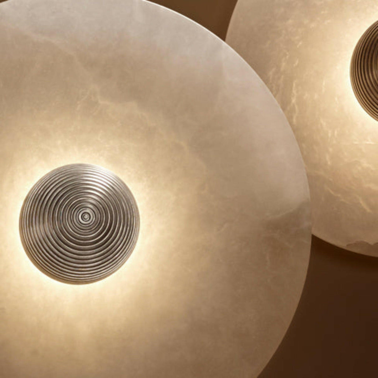 Round wall lights with a metallic decorative element on a brown background