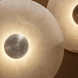 Round wall lights with a metallic decorative element on a brown background