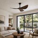 Modern living room with a ceiling fan, sofa, coffee table, and large windows.
