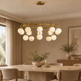 Marble ball light – 100cm Brass – lifestyle Installed above dining table in elegant warm beige dining room, ceiling connection visible, exact scale relative normal furniture.