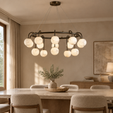 Marble ball light – 100cm Black – lifestyle Installed above dining table in elegant warm beige dining room, ceiling connection visible, exact scale relative normal furniture.