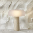 Beige table lamp with a textured base on a marble surface