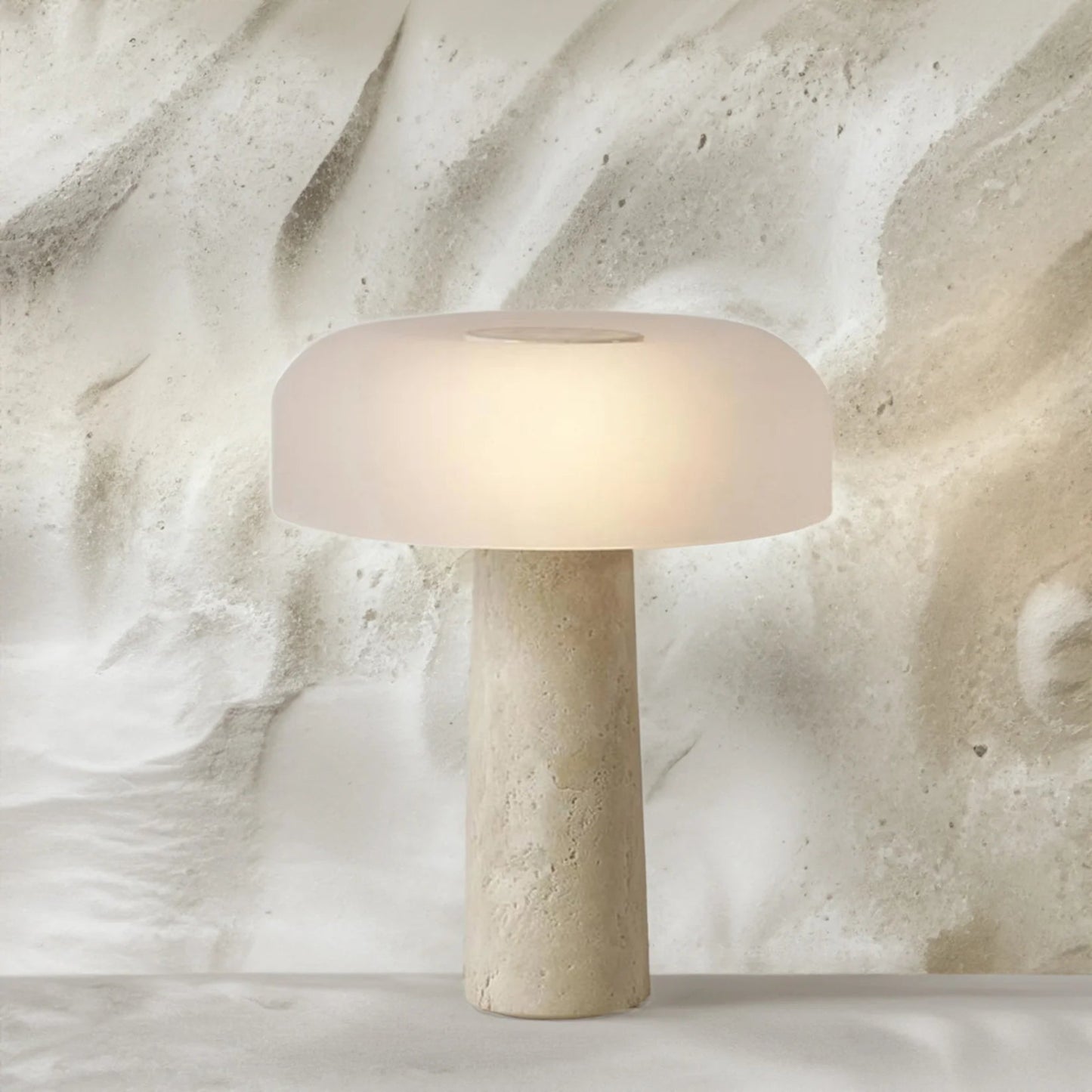 Beige table lamp with a textured base on a marble surface