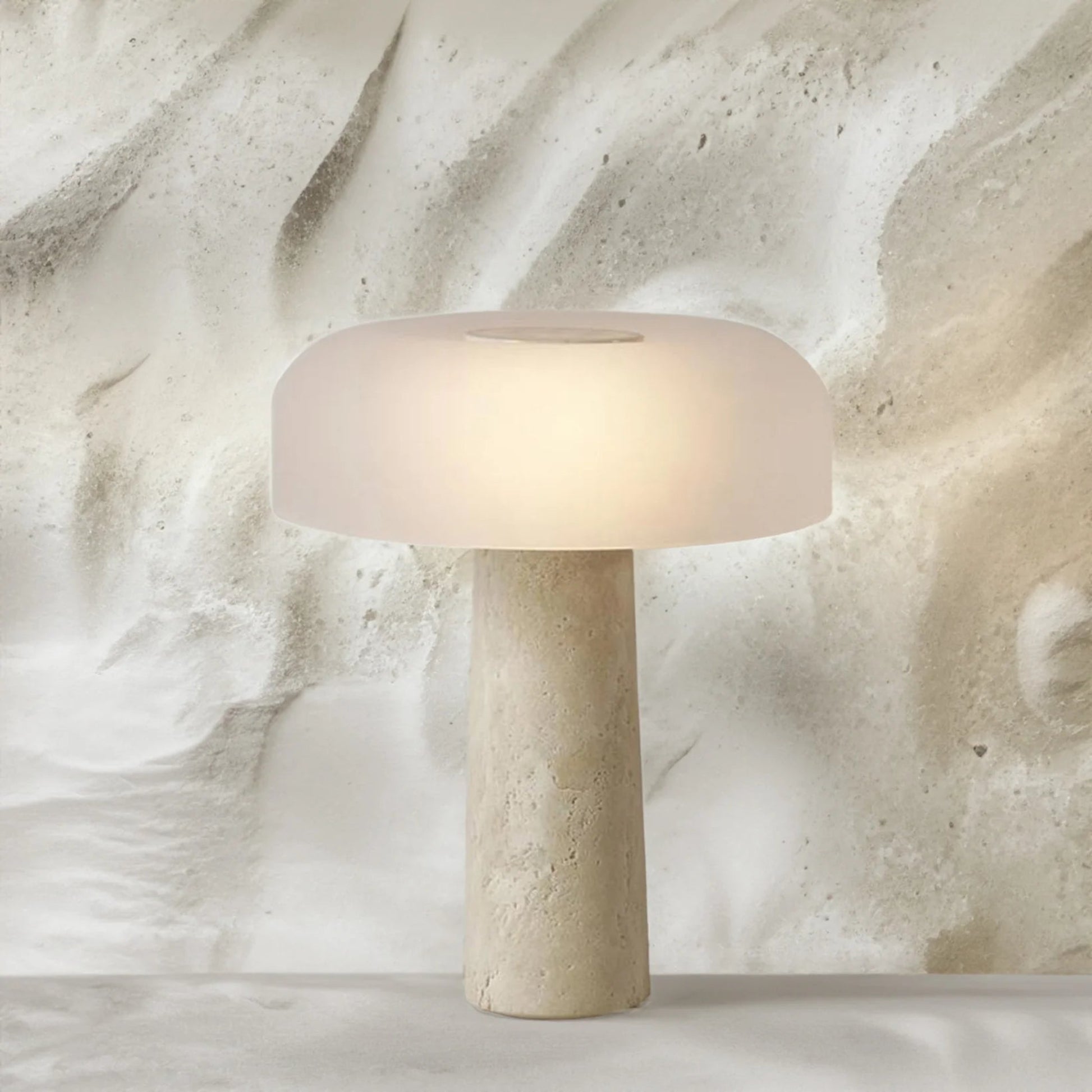 Beige table lamp with a textured base on a marble surface