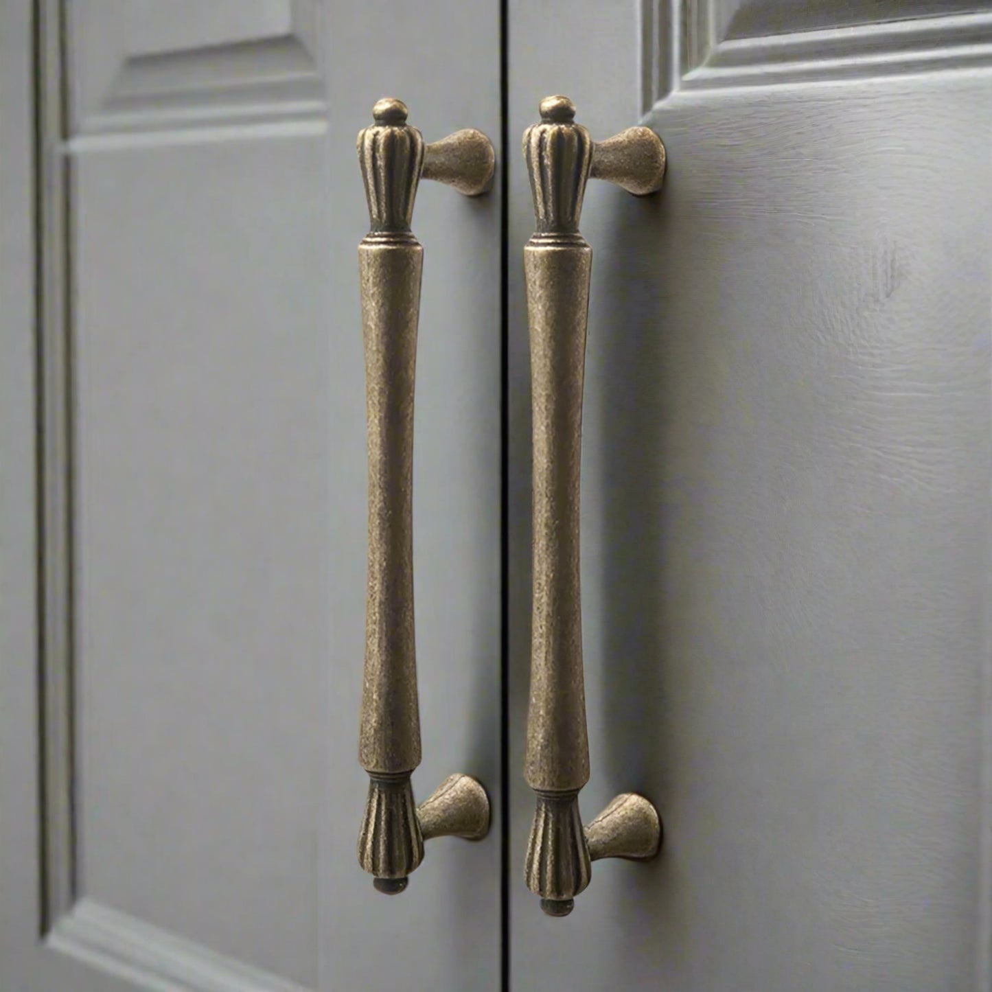 Pair of bronze cabinet handles on a gray door