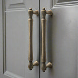 Pair of bronze cabinet handles on a gray door
