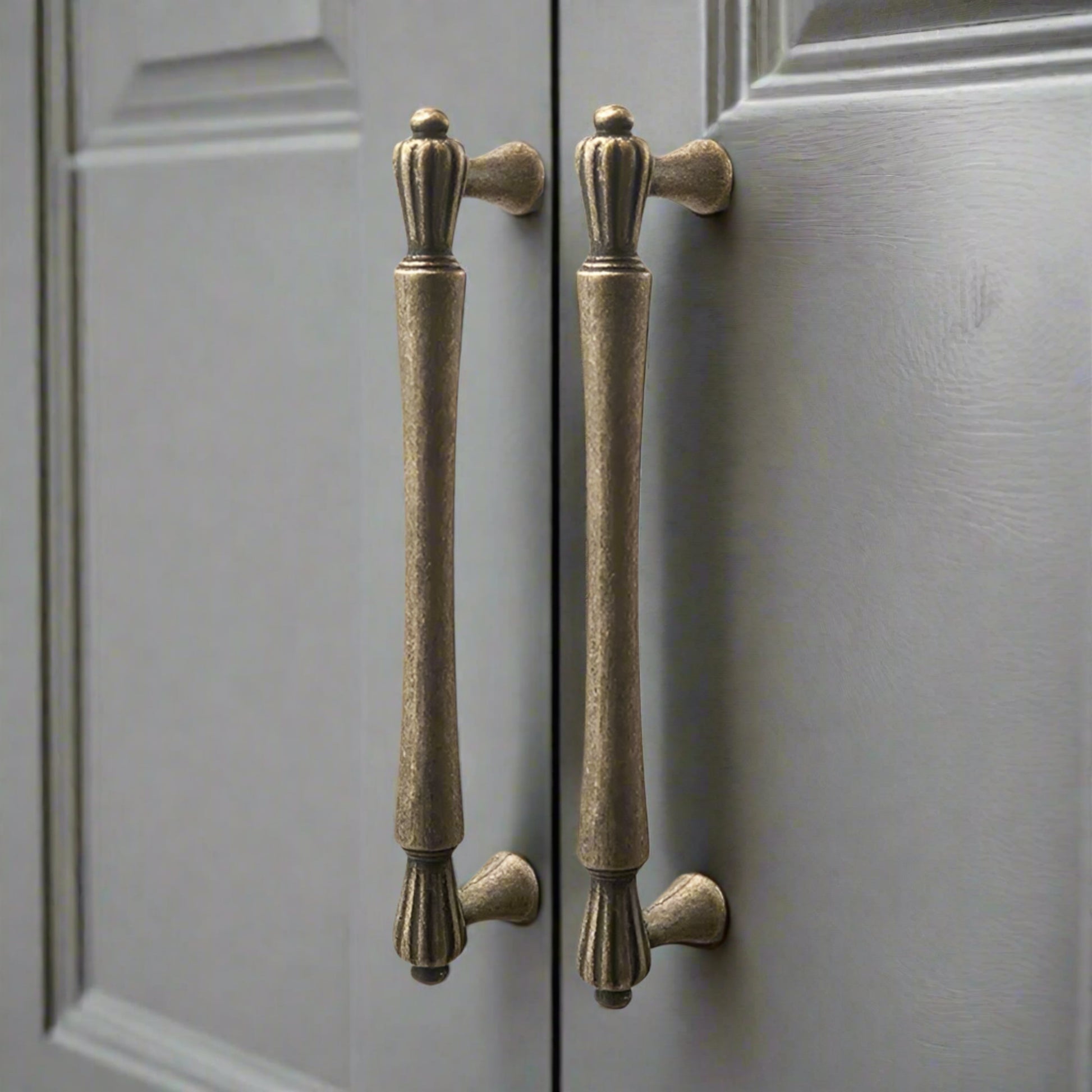 Pair of bronze cabinet handles on a gray door