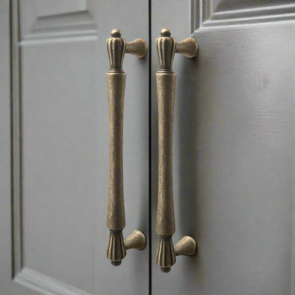 Pair of bronze cabinet handles on a gray door
