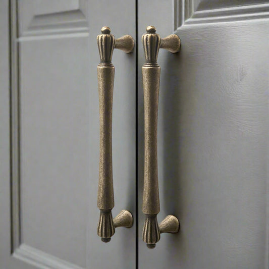 Pair of bronze cabinet handles on a gray door