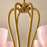 Close-up of a modern chandelier with curved gold metal arms and soft pink glass shades partially visible on both sides.
