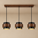 Three-light linear pendant ceiling fixture with dark wood and black metal shades, shown hanging against a beige wall.