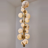 Chandelier with round, marble-like lampshades on a neutral background