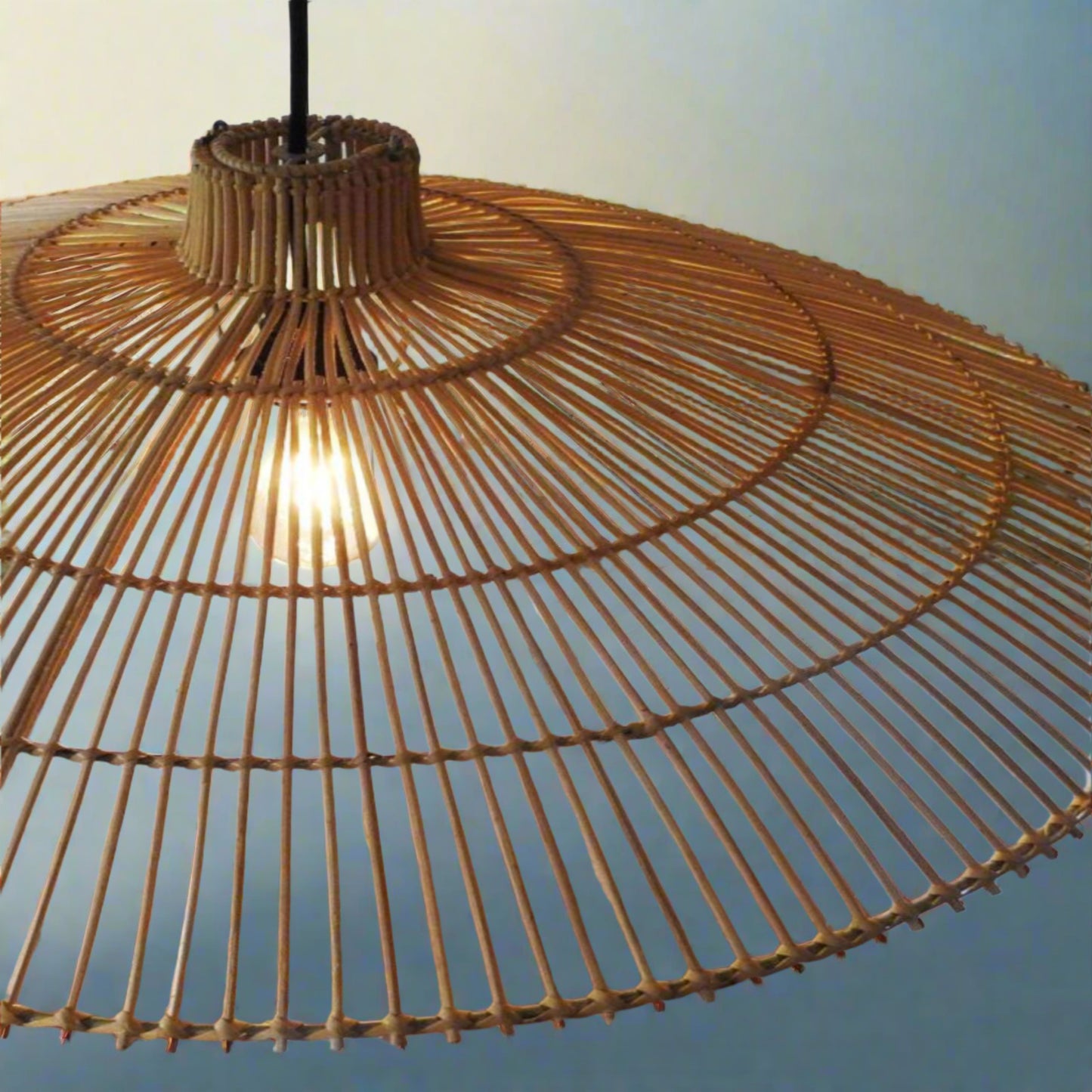 Close-up of a wicker umbrella with a blurred outdoor background