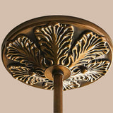 Close look at decorative bronze ceiling medallion with leaf pattern on a white background