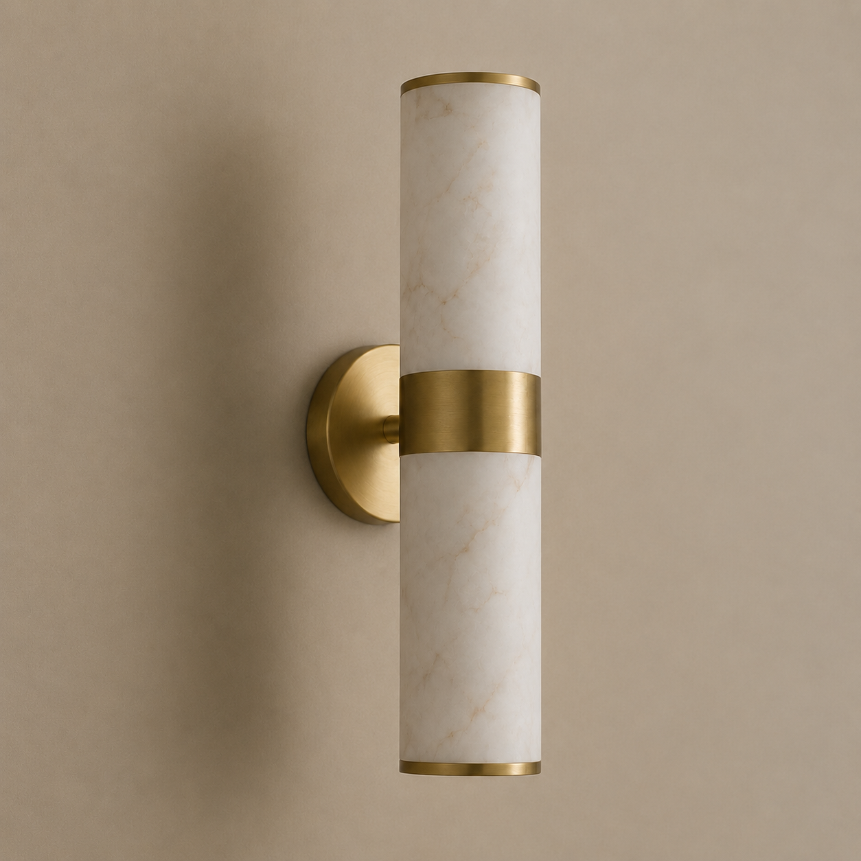A modern cylindrical wall sconce with a white marble-look glass shade and brushed gold metal accents, mounted on a warm beige wall.
