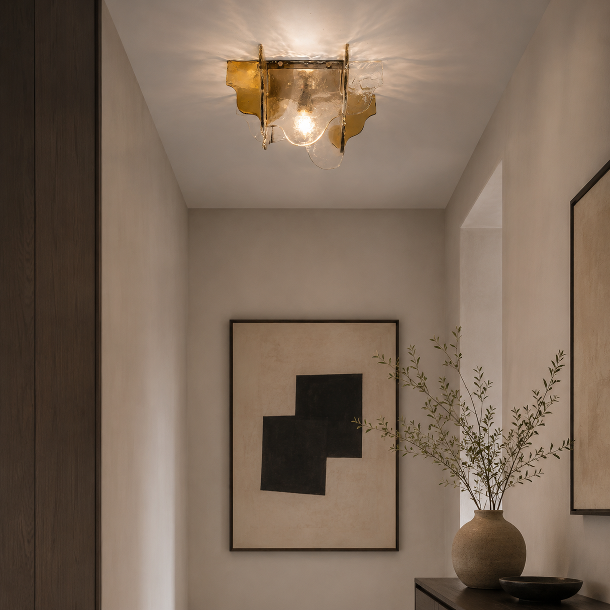Modern ceiling light fixture in a room with abstract art and a vase.