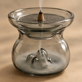 Close-up of glass mountain incense burner with removable honeycomb mesh and cone incense