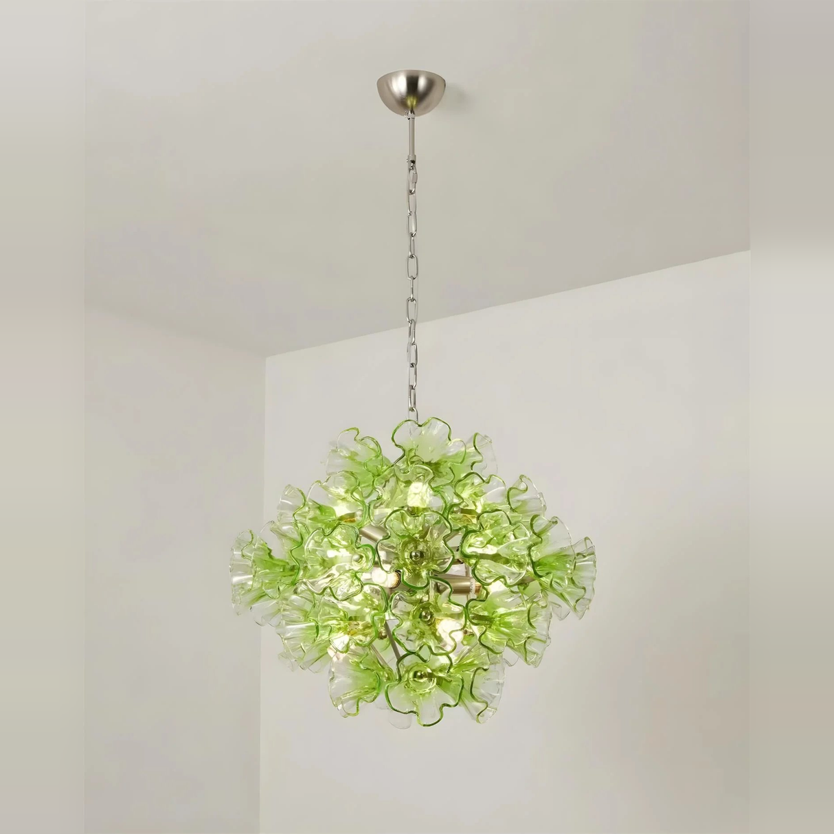 Green floral chandelier hanging against a plain background