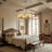 A luxury bedroom featuring a dark wood four-poster bed with beige linens, a matching wooden bench at the foot of the bed, a modern multi-light chandelier, and a cozy desk setup by a window.
