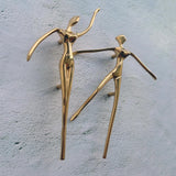 Gold abstract sculptures on a textured gray surface