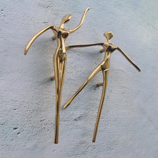 Gold abstract sculptures on a textured gray surface