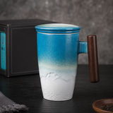 Kuro Artisan Ceramic Tea Infuser Mug in blue and white glaze with wooden handle in a premium studio setting