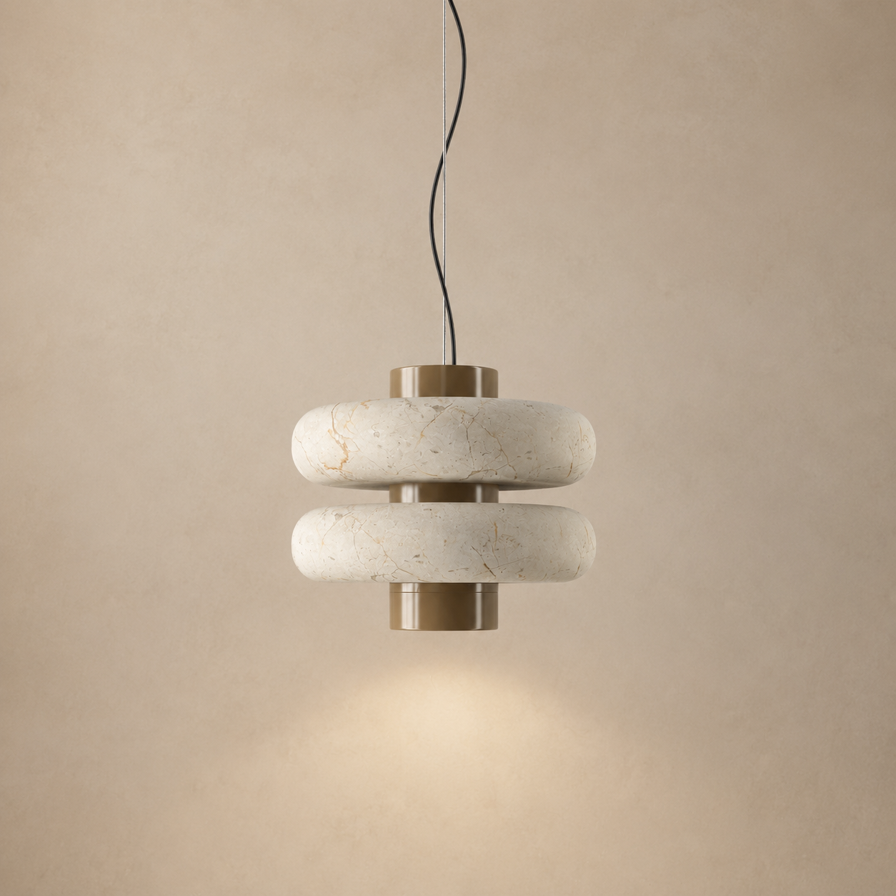 A modern two-tier pendant light fixture with textured off-white stone rings and brushed brass metal accents, suspended against a warm beige textured wall.