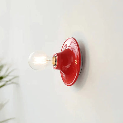 Red wall sconce with a light bulb on a white background