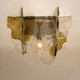 Decorative wall sconce with a glass shade on a plain background